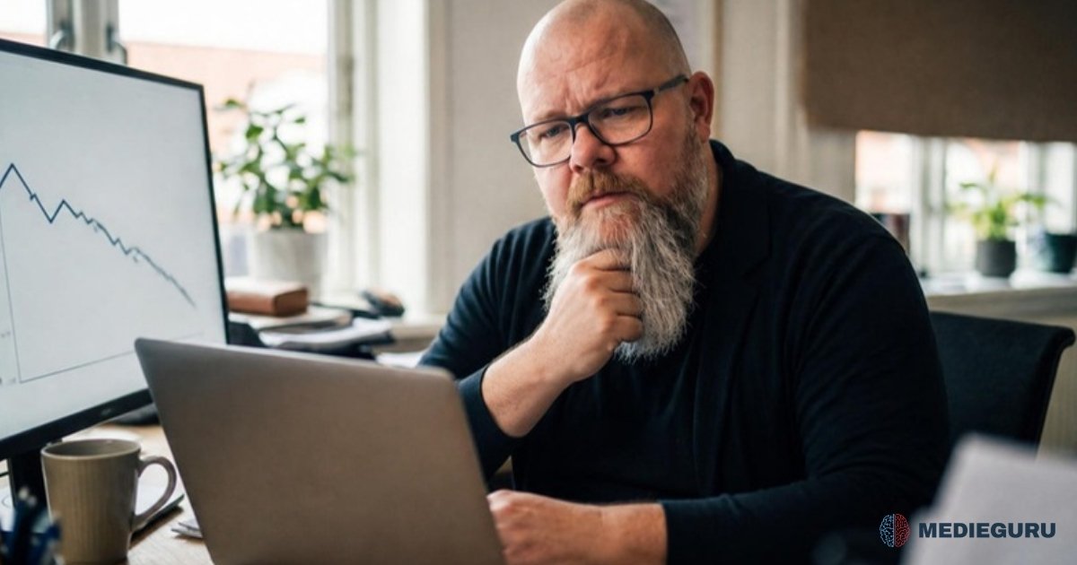 Thor Jadesø sidder ved skrivebordet med hånden i skægget og kigger eftertænksomt på en faldende kurve på skærmen